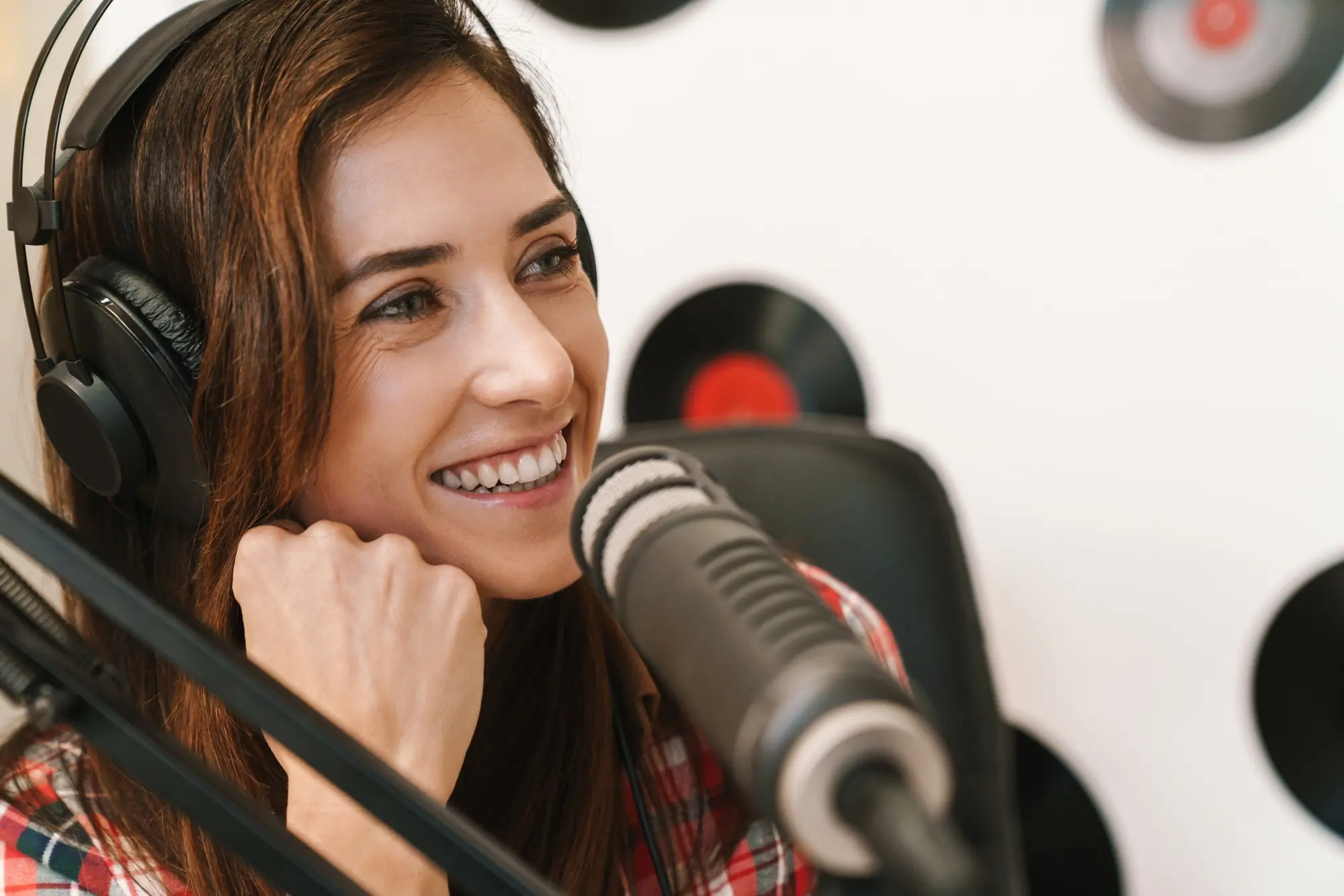 Host speaking into studio microphone during podcast and audio content production
